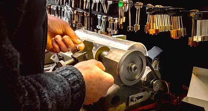 Técnico de Cerrajería Reyes tallando con precisión una llave de vehículo en el taller de Sabadell