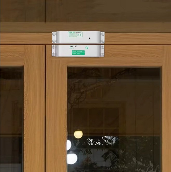 Instalación de cierre magnético Fail-Safe sobre el dintel de una puerta de madera con vidriería.