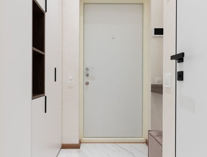 Primer plano de puerta blanca moderna con sistema de apertura técnica y panel inteligente, optimizando la seguridad residencial en Sabadell.