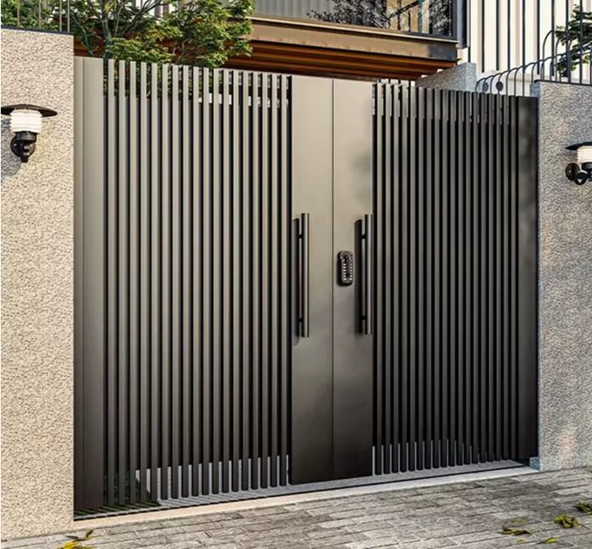 Puerta motorizada contemporánea instalada por Cerrajería Reyes en zona residencial del Vallès, dotada de cierre perimetral inteligente.