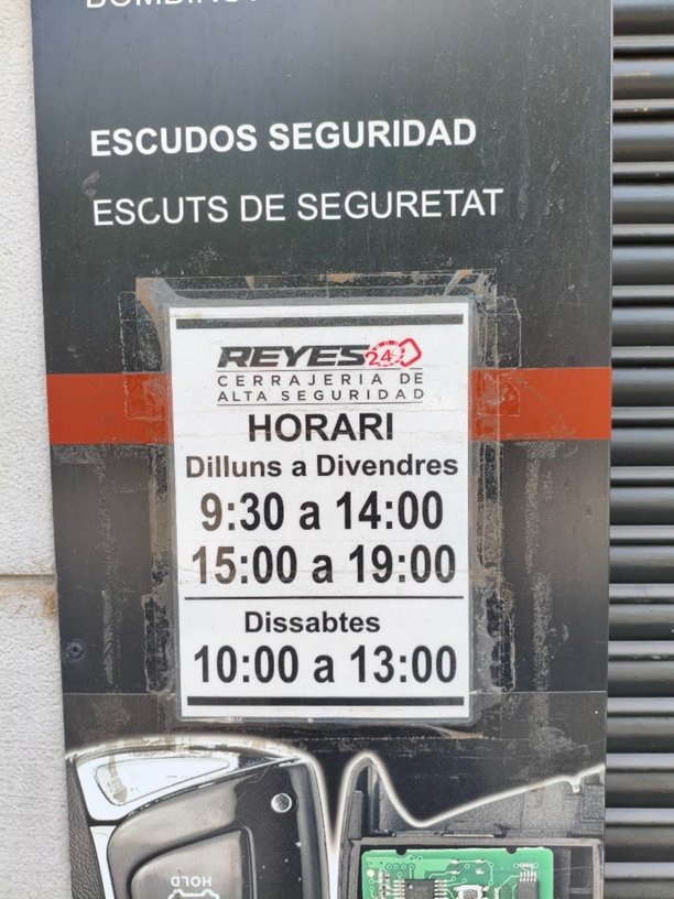 Adiós Timos: Nuestro Local Acreditado con su Cartel informativo de horarios y servicios técnicos de proximidad en el escaparate de Cerrajería Reyes Sabadell.