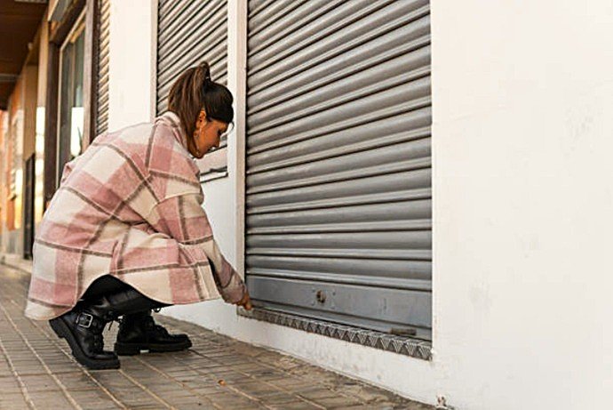 Cierre de seguridad para persiana comercial metálica con anclaje de suelo instalado en Sabadell.